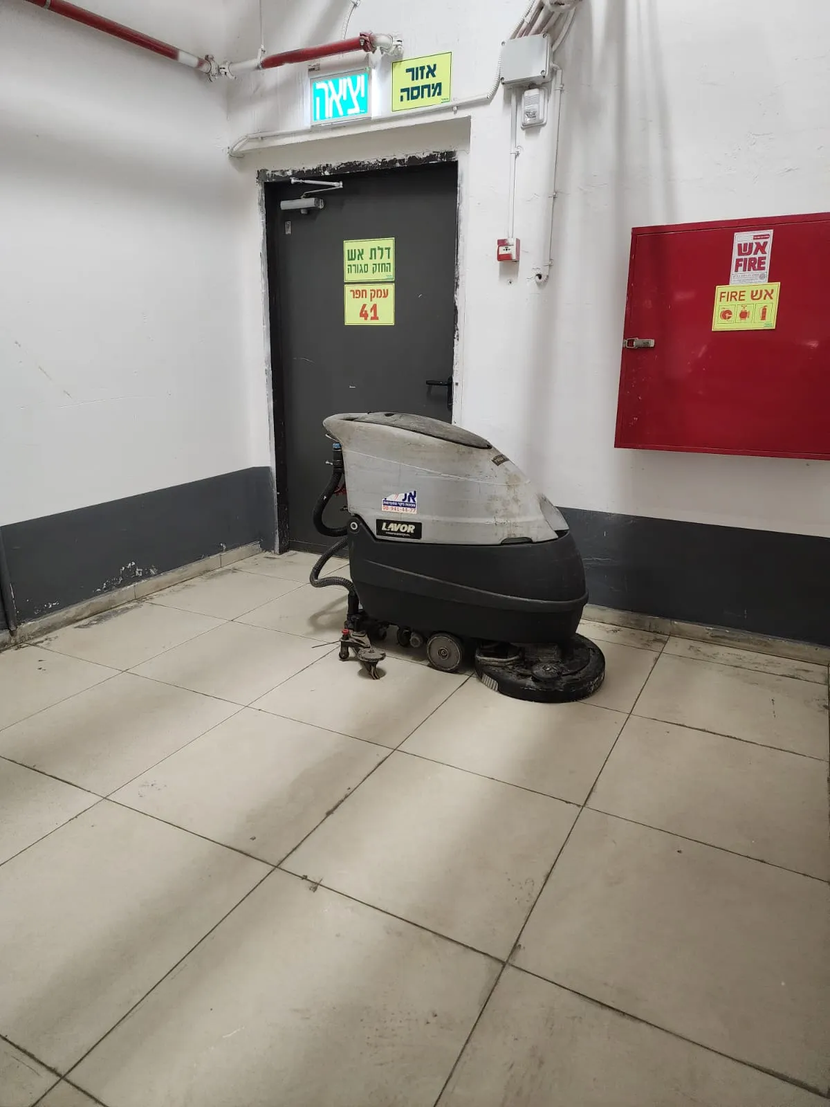 מכונת שטיפת רצפות בלובי של בניין, ניקיון שוטף של צוות אל ג׳י